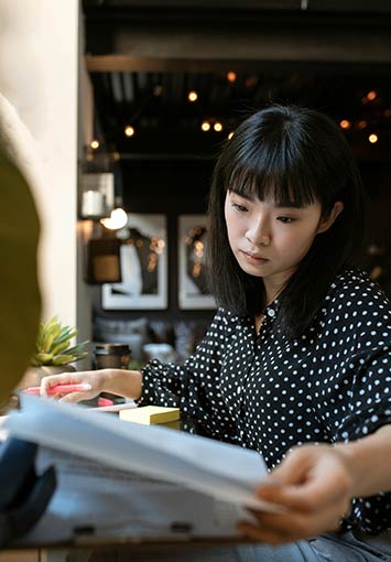 Woman working with paper documents in an office setting